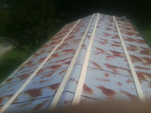 Rusted metal roof panels with new wood purlins before replacement — Storm Damage Roof Repair in Paxinos by Roofing Brothers