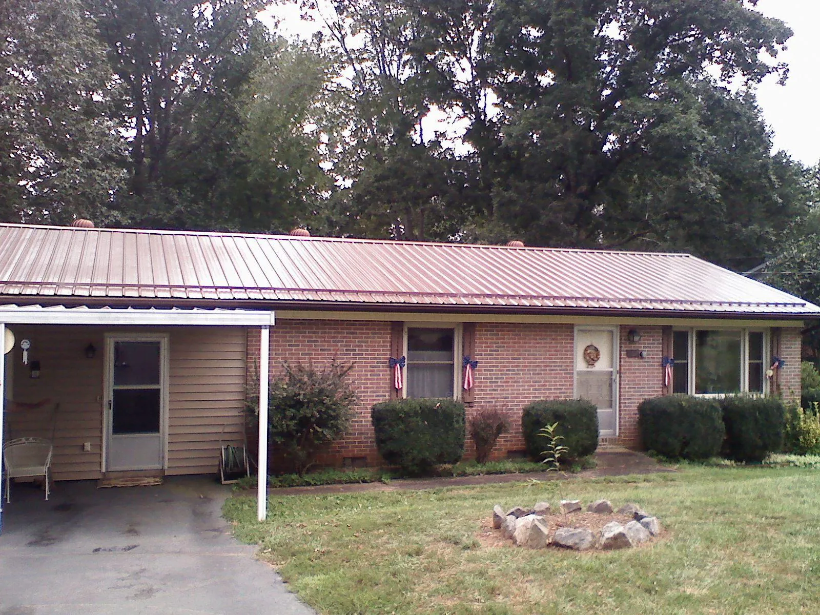 Bronze metal roof and carport on a brick ranch home — Roof Repair work by our crew in Paxinos